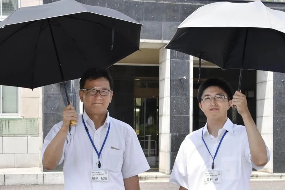 Au Japon, où la chaleur est accablante, les hommes se tournent vers les ombrelles pour se rafraîchir